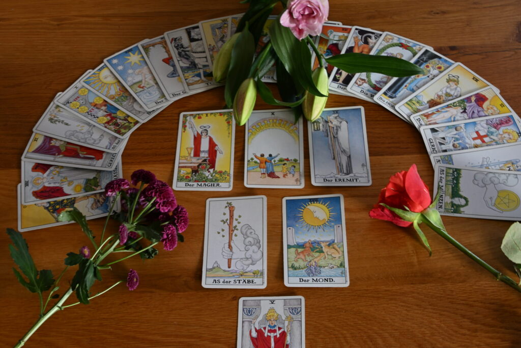 Tarotkarten im Kreis mit Rosen, Lilien und Chrysanthemen dekoriert