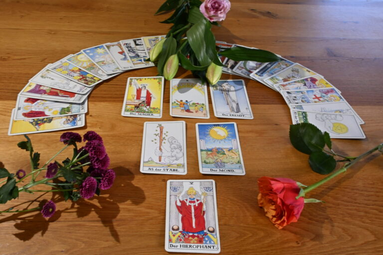 Tarot-Legung in Kreisform mit Rose und Lilienzweig