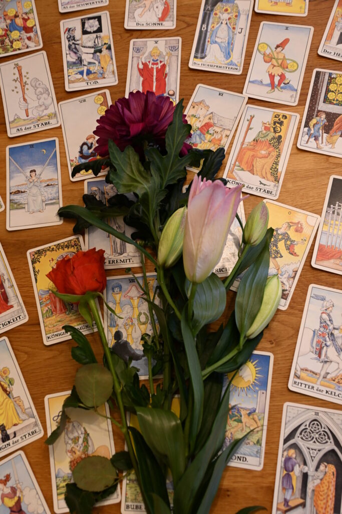 Bouquet aus Tulpen und Rosen liegt über einer Tarot-Legung